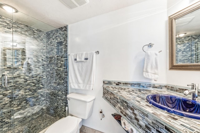 bathroom featuring a stall shower, visible vents, a sink, and toilet