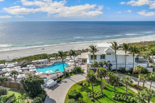 birds eye view of property with a water view and a beach view