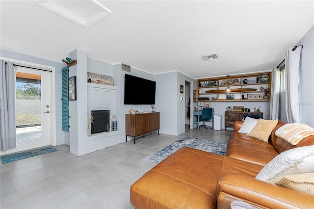 living room with attic access, visible vents, and a fireplace