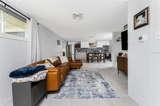 living room featuring light tile patterned floors and visible vents