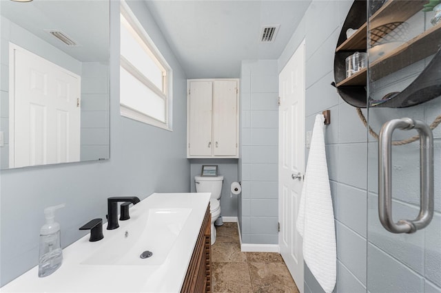 bathroom with toilet, visible vents, and vanity