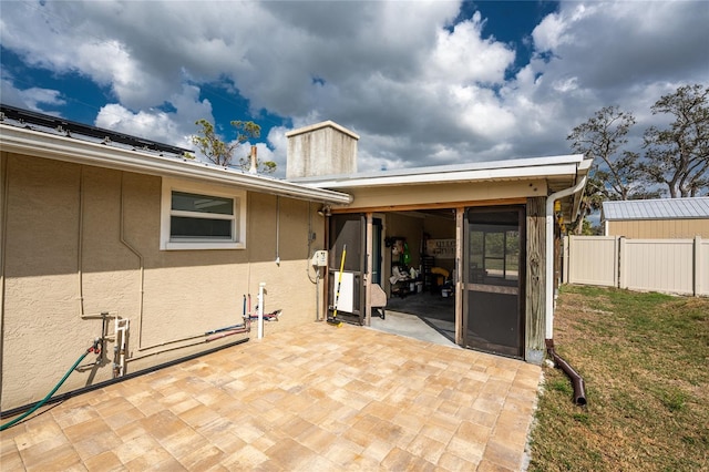 exterior space with a patio area, fence, and stucco siding