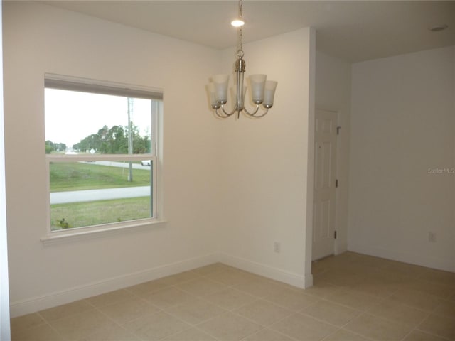 unfurnished dining area with baseboards and an inviting chandelier