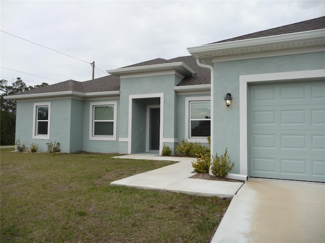 view of front facade featuring a shingled roof, a front yard, and stucco siding