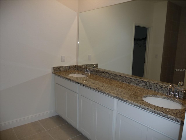 full bathroom with double vanity, baseboards, a sink, and tile patterned floors