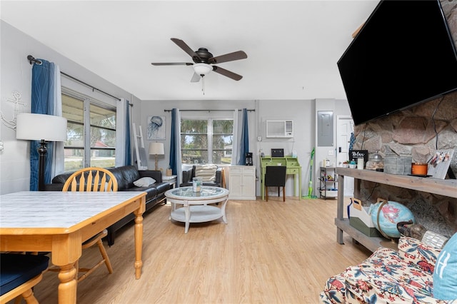 living area with an AC wall unit, ceiling fan, and light wood finished floors