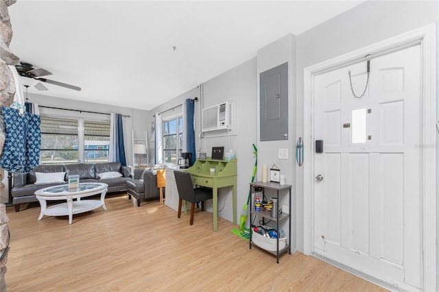 living area featuring a wall mounted AC, light wood-type flooring, electric panel, and a ceiling fan