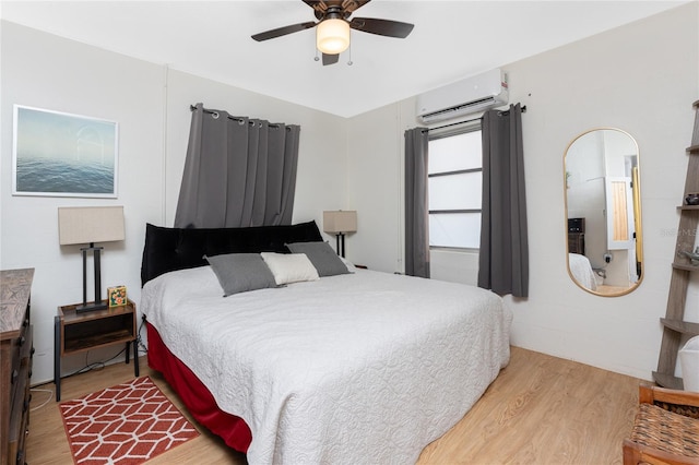 bedroom featuring a wall mounted air conditioner, ceiling fan, and wood finished floors