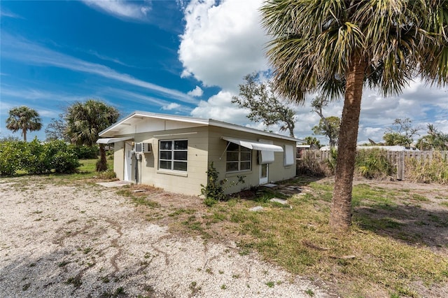 back of property featuring concrete block siding and fence