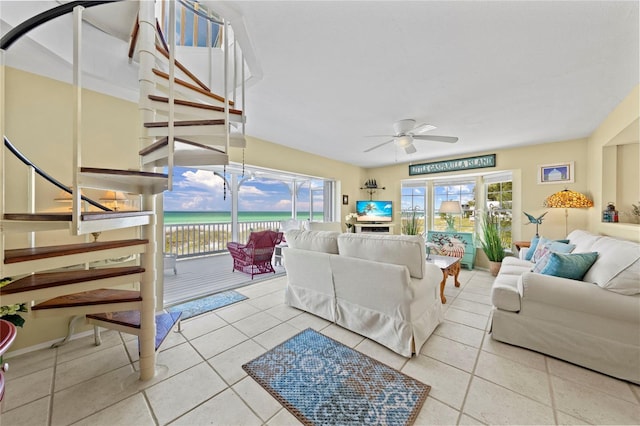 living room with stairs, tile patterned floors, and ceiling fan