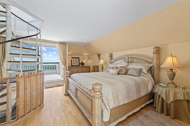 bedroom with lofted ceiling, access to outside, and light wood-style flooring