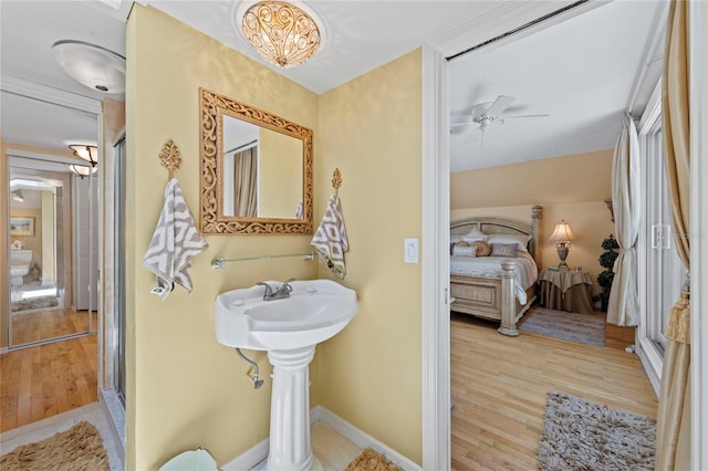 ensuite bathroom featuring a shower stall, connected bathroom, ceiling fan, and wood finished floors