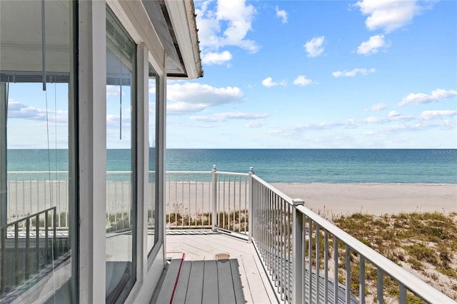 balcony featuring a water view and a view of the beach