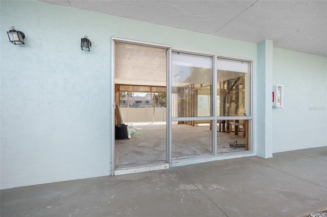 view of exterior entry featuring stucco siding