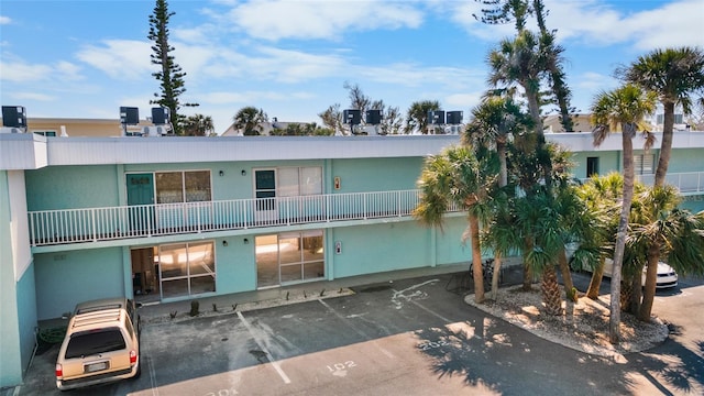 view of property with uncovered parking and central AC