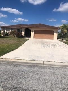 view of front of property featuring driveway, a front lawn, and an attached garage