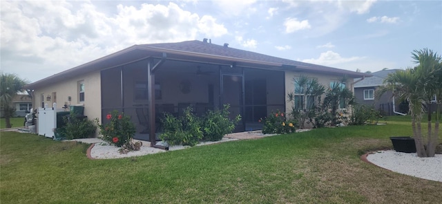 view of side of home featuring a yard, a sunroom, and stucco siding