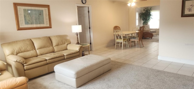 living room with a ceiling fan, light tile patterned flooring, and baseboards