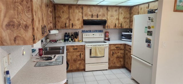 kitchen with light countertops, white appliances, brown cabinets, and ventilation hood