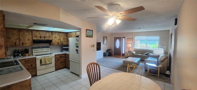 kitchen featuring white appliances, open floor plan, light countertops, ventilation hood, and brown cabinetry