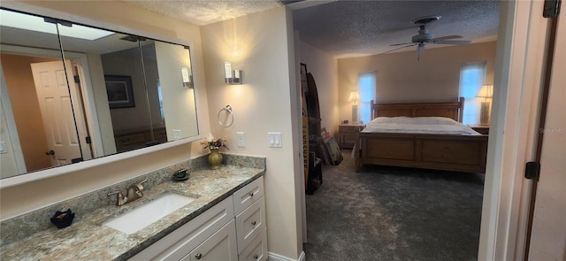 bathroom featuring a ceiling fan, a textured ceiling, and vanity