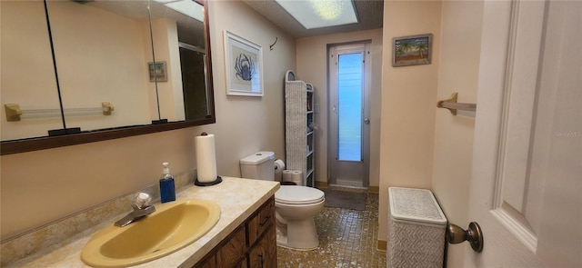 bathroom featuring toilet, a shower, and vanity