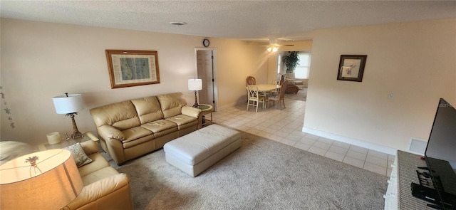 living room featuring baseboards, visible vents, a ceiling fan, tile patterned floors, and a textured ceiling