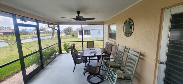 sunroom with a water view and ceiling fan