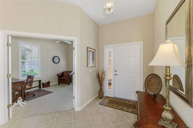 entrance foyer featuring light tile patterned floors, light colored carpet, and baseboards