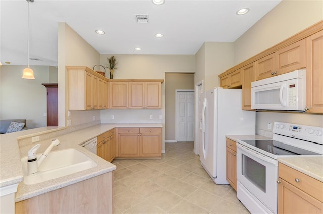 kitchen featuring light brown cabinetry, visible vents, white appliances, and a sink