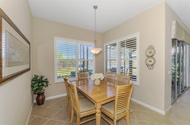 dining area featuring light tile patterned floors and baseboards