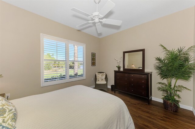 bedroom featuring dark wood finished floors, a ceiling fan, and baseboards