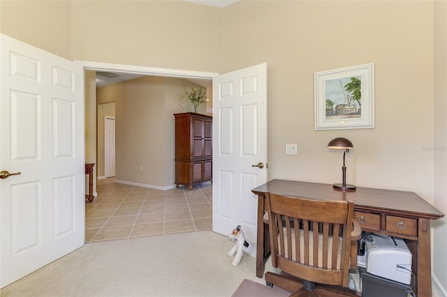 office area featuring light tile patterned floors, baseboards, and light carpet