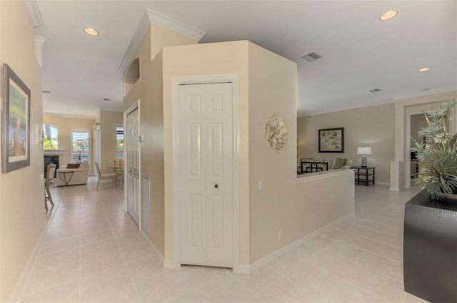 hall with recessed lighting, baseboards, crown molding, and light tile patterned floors