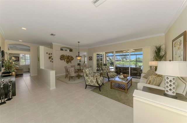 living area featuring crown molding, light tile patterned flooring, and visible vents