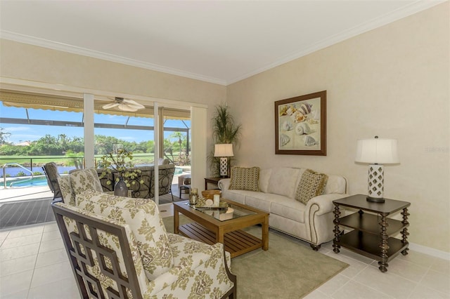 living room featuring ceiling fan, baseboards, ornamental molding, light tile patterned floors, and a sunroom