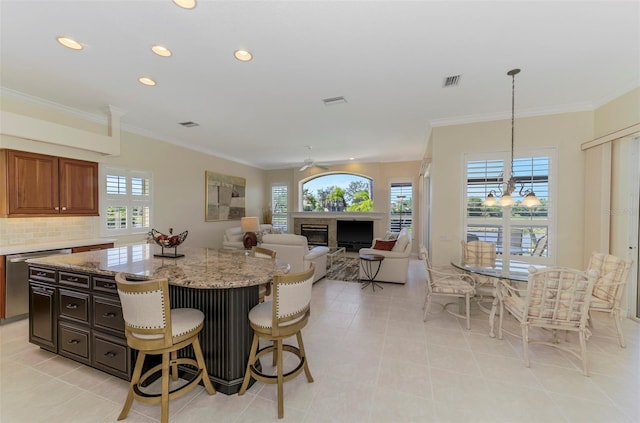 kitchen with visible vents, dishwasher, crown molding, and a glass covered fireplace