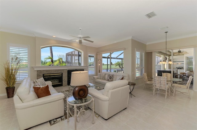 living area featuring visible vents, a fireplace, and crown molding