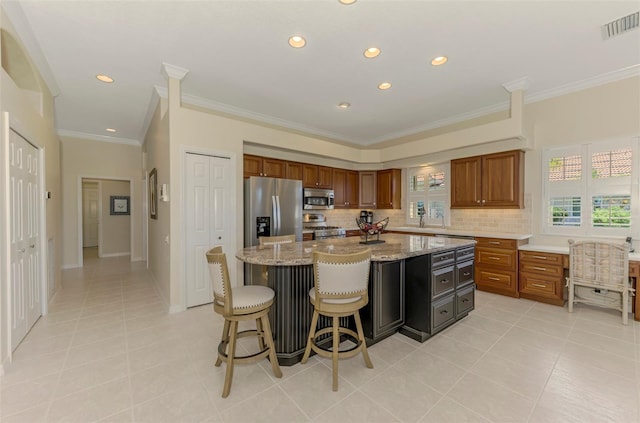 kitchen with tasteful backsplash, visible vents, appliances with stainless steel finishes, and a center island