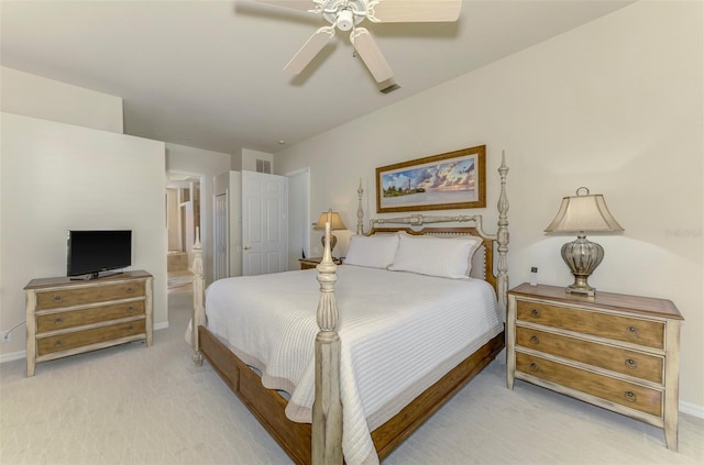 bedroom featuring visible vents, ensuite bathroom, a ceiling fan, baseboards, and light colored carpet