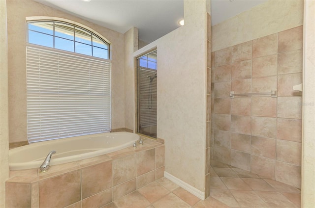 bathroom with a bath, tile patterned flooring, and a tile shower