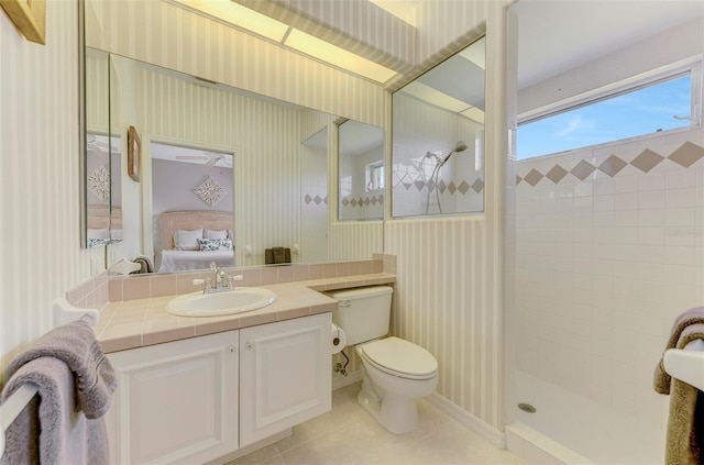 ensuite bathroom with tiled shower, wallpapered walls, ensuite bath, tile patterned floors, and toilet