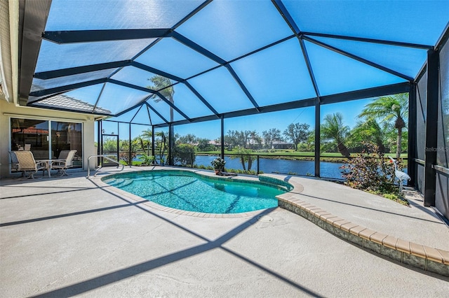 outdoor pool with glass enclosure, a patio, and a water view