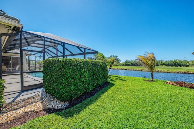 view of yard featuring glass enclosure, an outdoor pool, and a water view