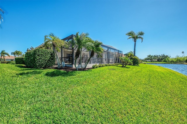 view of yard with a lanai and a water view