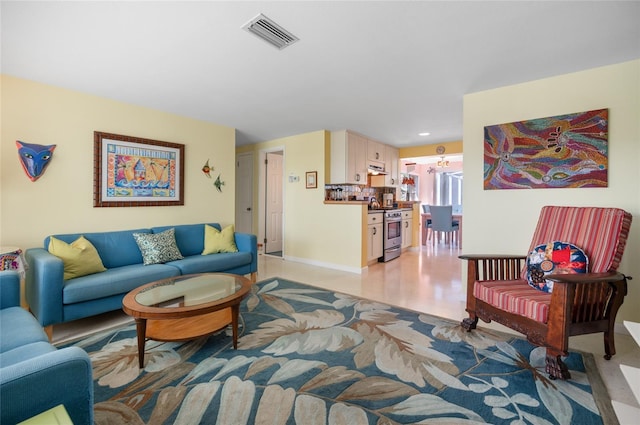 living room featuring light wood-type flooring, visible vents, and baseboards