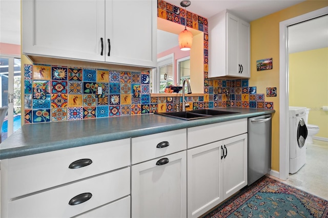 kitchen with tasteful backsplash, a sink, white cabinetry, and washer and dryer