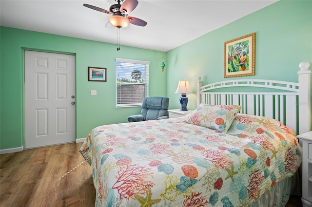 bedroom with ceiling fan, baseboards, and wood finished floors