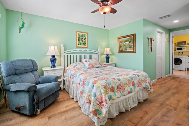 bedroom with a ceiling fan, baseboards, visible vents, washer and dryer, and light wood-type flooring