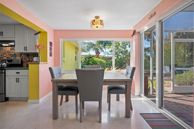 dining room with light speckled floor and baseboards